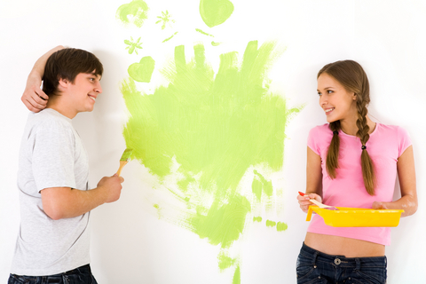 Kille och tjej målar vägg